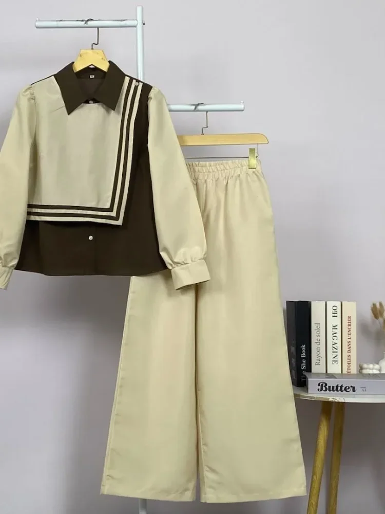 ASAYA Atasan lengan panjang memiliki efek lapisan ganda, dipadukan dengan rompi warna kontras dan celana panjang warna sama, dilapisi lagi dengan celana panjang set dua potong