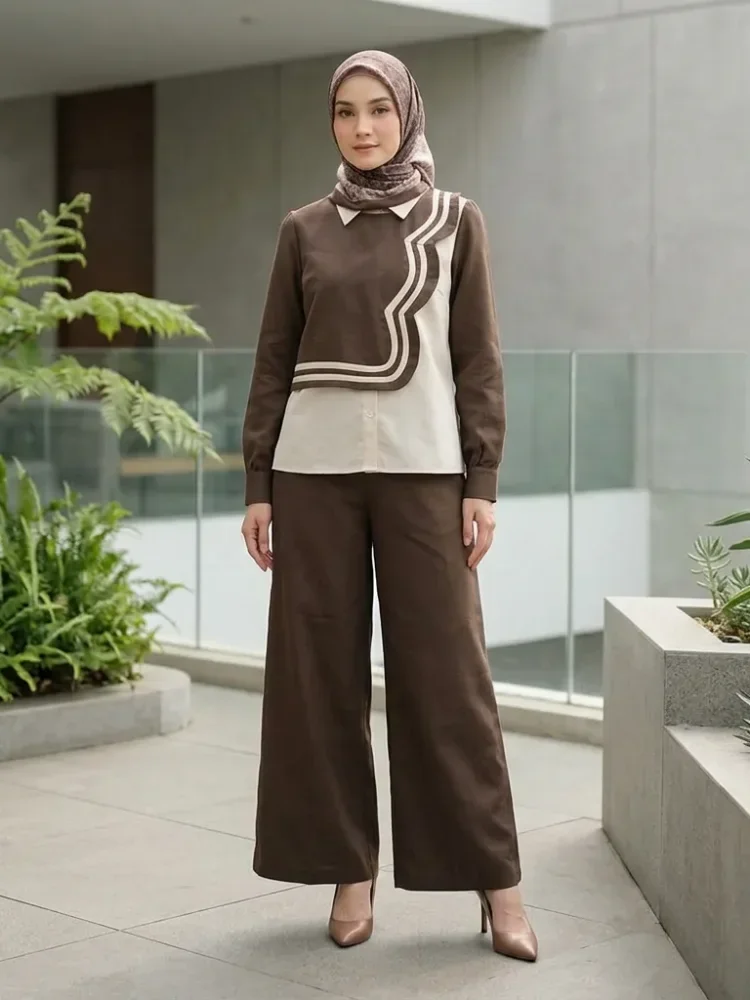 ASAYA Atasan lengan panjang desain braun memiliki efek dua lapis, dipadukan dengan rompi warna kontras dan celana panjang senada, lalu ditumpuk dengan celana panjang setelan tambahan.