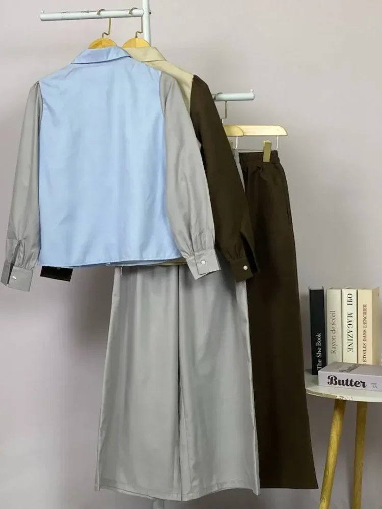 ASAYA Atasan lengan panjang desain braun memiliki efek dua lapis, dipadukan dengan rompi warna kontras dan celana panjang senada, lalu ditumpuk dengan celana panjang setelan tambahan.
