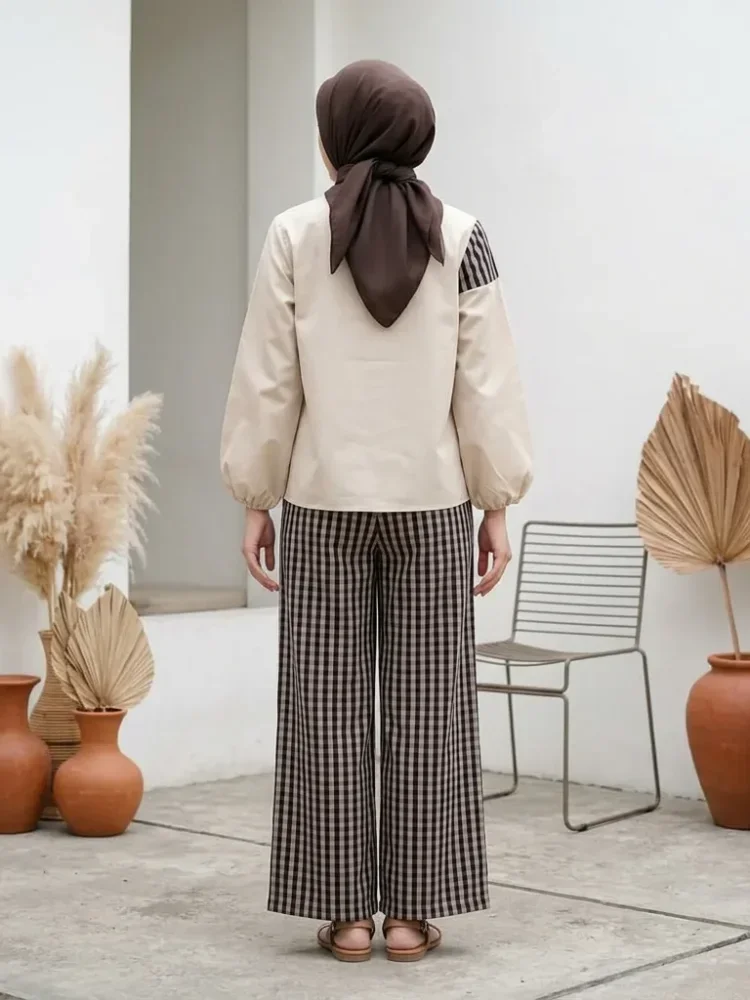 ASAYA Atasan dua potong dengan desain patchwork asimetris dan gaya minimalis, dipadukan dengan celana yang nyaman.