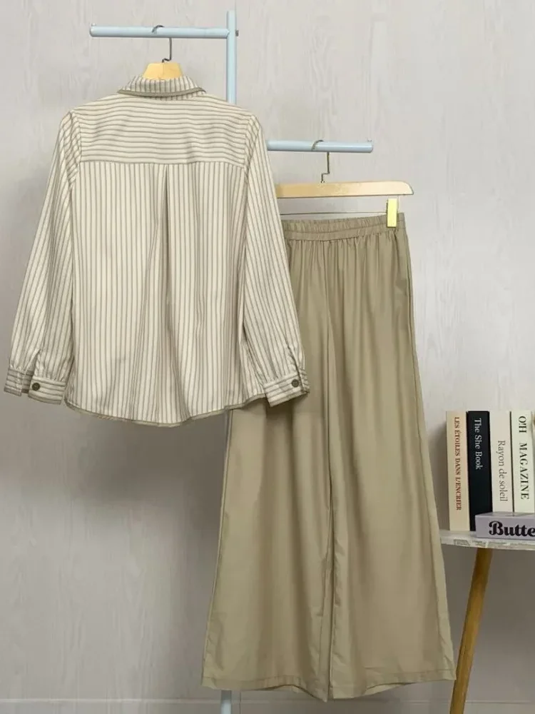 ASAYA Setelan dua potong: kemeja lengan panjang dengan desain kancing unik di bagian bawah dan kerah, dipadukan dengan celana panjang lebar polos